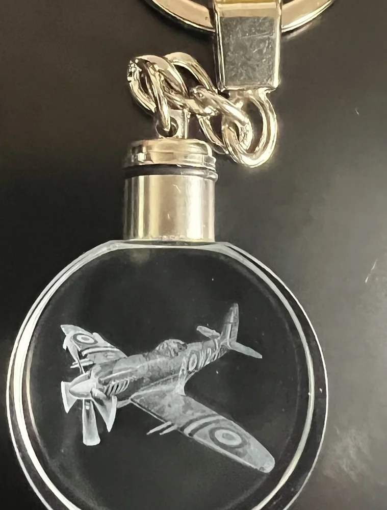 Circle K9 crystal keychain with a Spitfire plane engraved inside, on a silver keyring